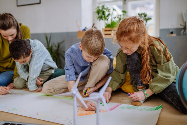 Children drawing a project to environmental lesson in school.