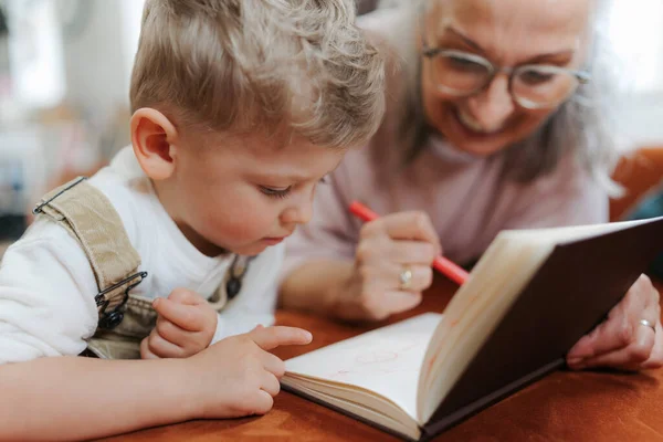 Großmutter Zeichnet Mit Ihrem Kleinen Enkel Notizblock — Stockfoto