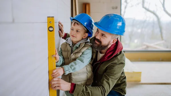 父亲和他的小儿子一起在他们未完工的房子里干活 — 图库照片