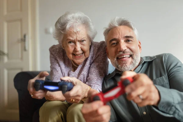 Зрелый Мужчина Навещает Свою Старшую Мать Доме Играет Видеоигры Вместе — стоковое фото