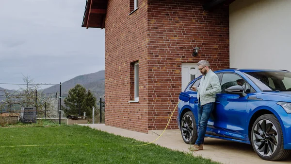 Olgun Adamı Yeni Elektrikli Arabasını Şarj Etmek Için Bekliyor — Stok fotoğraf