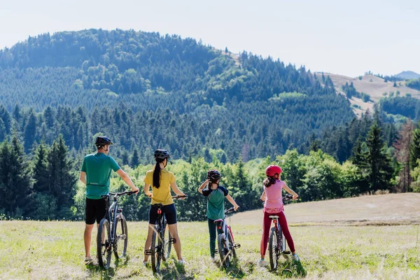 Young family with little children at a bike trip together in nature.