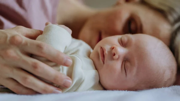 침대에서 태어난 아기와 껴안고 어머니 — 스톡 사진