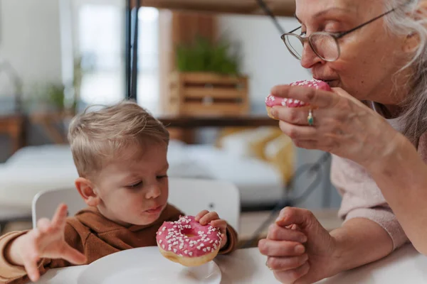 小男孩和他的祖母一起吃甜食 — 图库照片