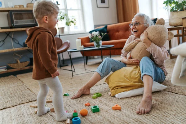 Бабушка Играет Своим Маленьким Внуком Медвежьей Игрушкой — стоковое фото