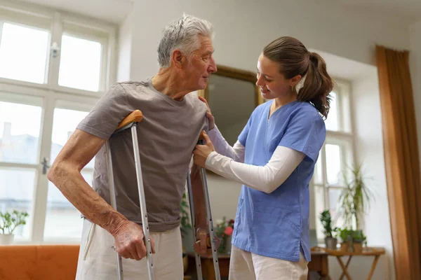 年轻的护士帮助一个老年人走路 — 图库照片