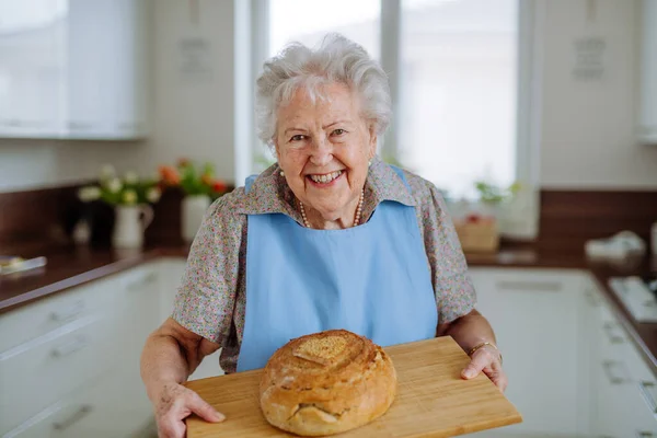 Portret Van Een Oudere Vrouw Met Een Vers Gebakken Brood — Stockfoto