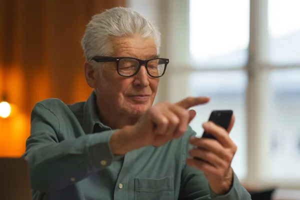 Uomo Anziano Scorrendo Suo Smartphone Casa Sua — Foto Stock