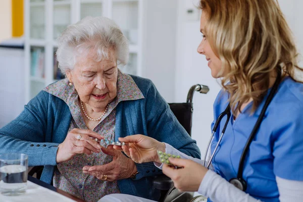 Медсестра Дает Таблетки Пожилой Женщине Доме — стоковое фото