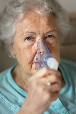 Astım spreyi ve sağlık sigortası konsepti olan yaşlı bir kadının portresi..