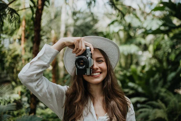 ジャングルの中のカメラを持つ若い女性の肖像 — ストック写真