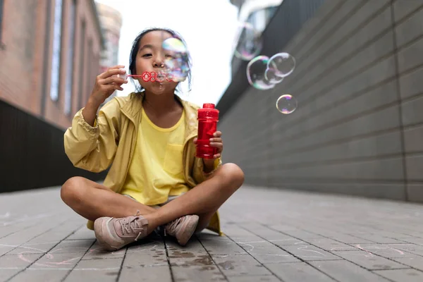Little Girl Sitting City Blowing Bubbles — Stockfoto