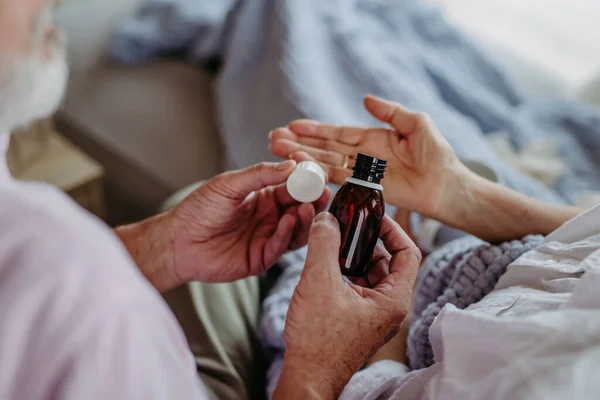 Крупный План Пожилого Человека Дающего Таблетки Своей Больной Жене Прием — стоковое фото