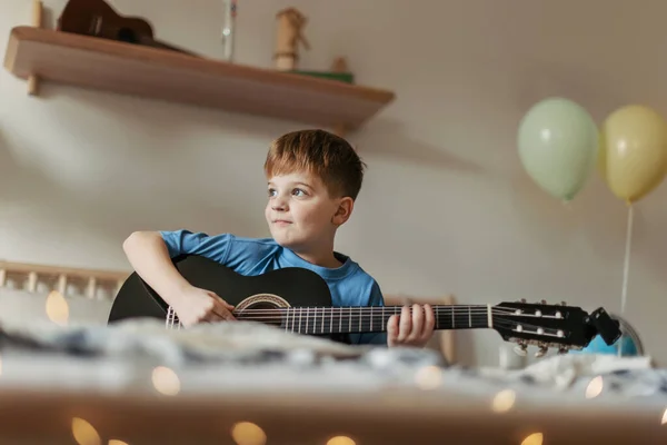 快乐的男孩一个人在房间里学习弹吉他 — 图库照片