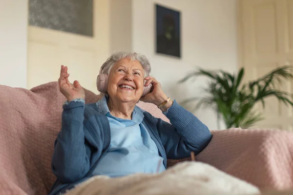 一个老年妇女坐在家里打电话的画像 老女人用智能手机说话 — 图库照片
