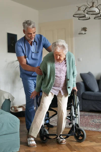 Φροντιστής Βοηθά Ηλικιωμένη Γυναίκα Σταθεί Από Την Αναπηρική Καρέκλα Στο — Φωτογραφία Αρχείου