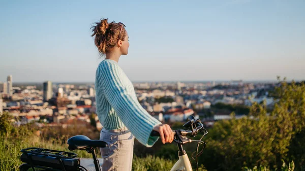 骑电动自行车的年轻妇女 通勤和生态旅行的概念 — 图库照片