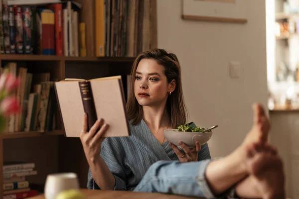 Kadın Evde Dinleniyor Kitap Okuyor Salata Yiyor — Stok fotoğraf