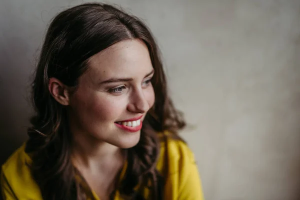 Eine Junge Frau Blickt Lächelnd Neben Ein Porträt Auf Grauem — Stockfoto