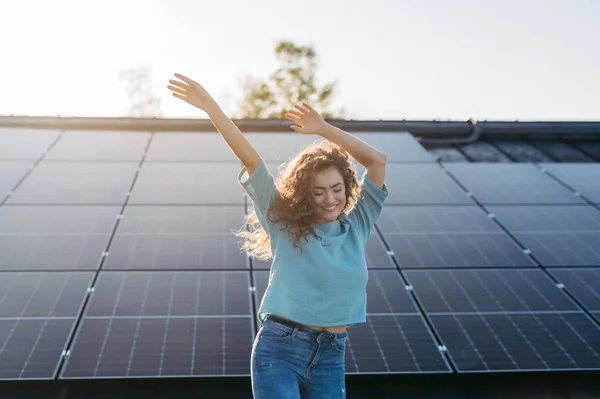 年轻兴奋女人的画像 屋顶上有太阳能电池板的所有者 — 图库照片