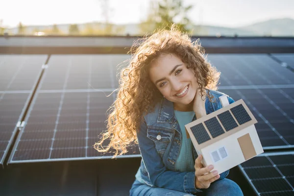 Portret Młodej Kobiety Właściciel Dachu Panelami Słonecznymi Trzymający Model Domu — Zdjęcie stockowe