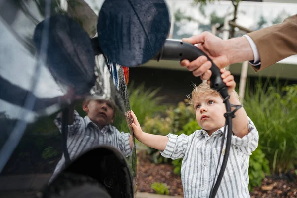 Küçük Oğluyla Birlikte Elektrikli Arabayı Şarj Ederken — Stok fotoğraf