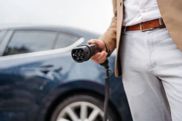 電気自動車を充電するビジネスマンの閉鎖 — ストック写真