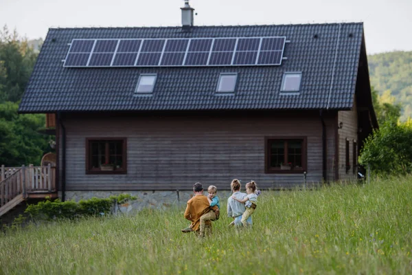 屋根の上にソーラーパネルを設置した幸せな家族 — ストック写真