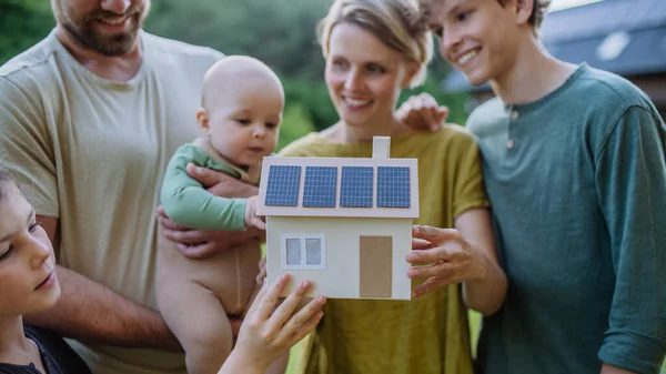 Szczęśliwa Rodzina Trójką Dzieci Trzymająca Model Domu Słonecznej Fotowoltaiki Alternatywna — Zdjęcie stockowe
