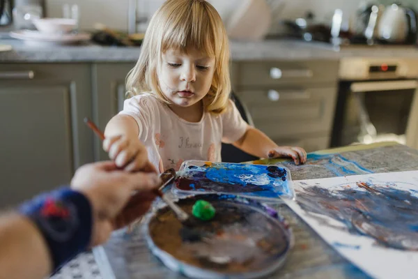 Отец Помогает Маленькой Девочке Рисовать Темперной Краской Дома Используя Кисть — стоковое фото