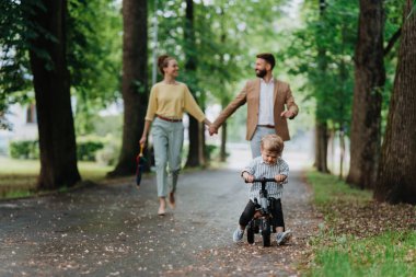 İşten sonra oğluyla şehir parkında yürüyüş yapan genç bir aile. Çalışan ebeveynler iş gününden sonra oğluyla vakit geçiriyorlar. Ebeveynler çocuğu kreşten alıyor..