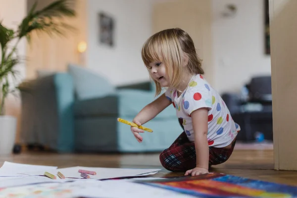 漂亮的小女孩 用蜡笔画着 坐在客厅的地板上 — 图库照片