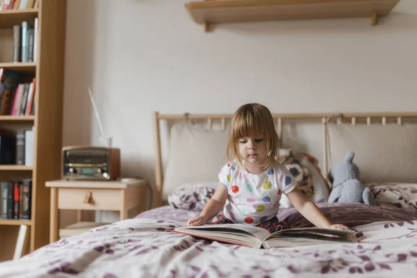 Kâküllü Kitap Okuyan Sevimli Küçük Bir Kız Çocuk Odasında Yatağında — Stok fotoğraf