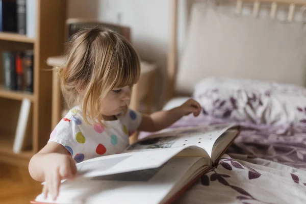 Roztomilá Holčička Ofinou Čtení Knihy Ležící Posteli Svém Dětském Pokoji — Stock fotografie