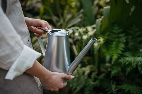 散水缶を保持する女性のクローズアップ 温室内の植物に水をやる — ストック写真