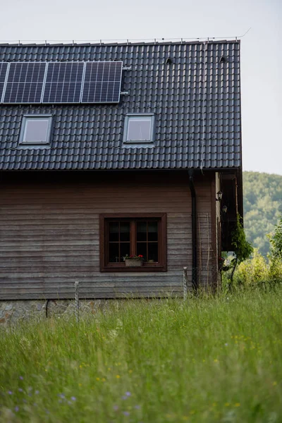 牧草地の屋根に太陽光パネル付きの家族の家 — ストック写真