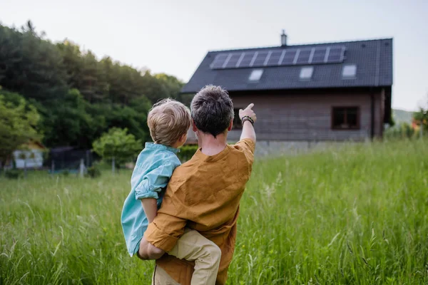 Vista Trasera Del Padre Hijo Mirando Casa Con Paneles Solares —  Fotos de Stock