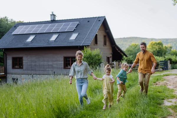 Glad Familj Framför Huset Med Solpaneler Taket — Stockfoto