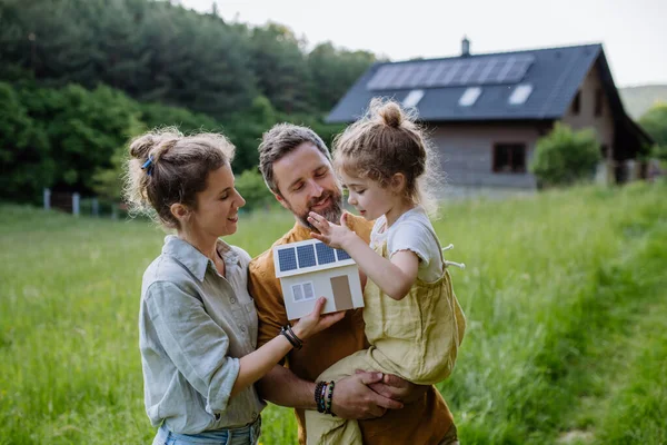Ευτυχισμένη Οικογένεια Μπροστά Από Σπίτι Τους Ηλιακούς Συλλέκτες Στην Οροφή — Φωτογραφία Αρχείου