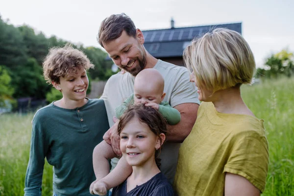ソーラーパネル付きの家の近くの幸せな家族 代替エネルギー 省資源 持続可能なライフスタイルの概念 — ストック写真