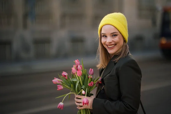 チューリップの花束を持つ都市の若い女性の肖像 — ストック写真