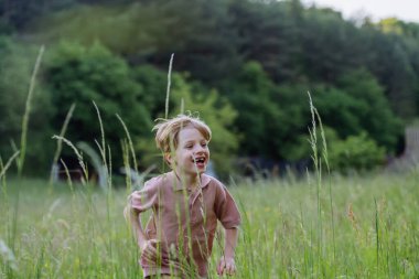 Mutlu çocuk çayırda koşup oynuyor..