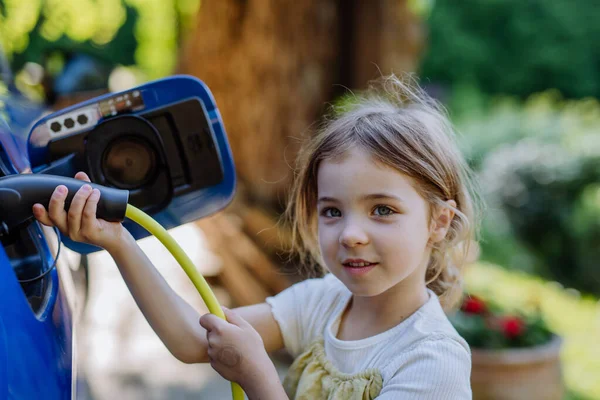 Kleines Mädchen Hält Netzkabel Und Lädt Das Elektroauto — Stockfoto