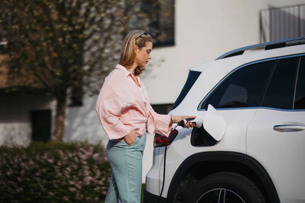 電気自動車 持続可能で経済的な交通の概念を充電する女性 — ストック写真