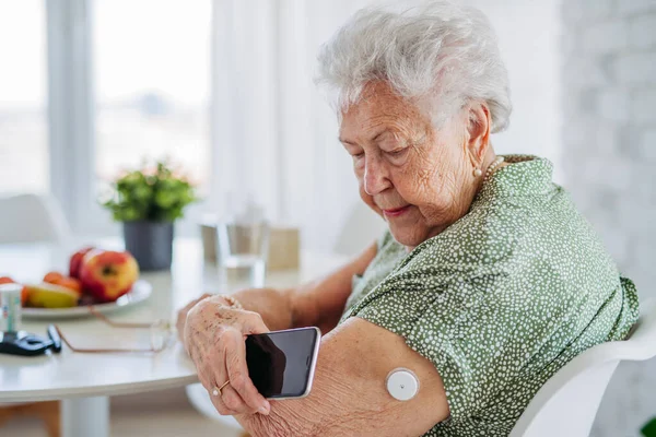 Diyabetik Kıdemli Hasta Devamlı Glikoz Monitörü Kullanarak Evdeki Kan Şekerini — Stok fotoğraf