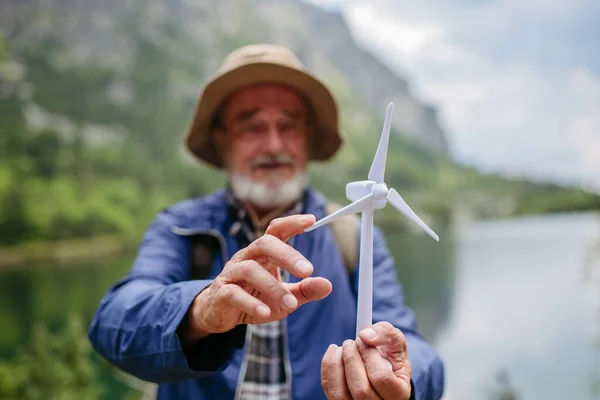 带着风力涡轮机模型的老游客的画像 那个背着背包旋转涡轮叶片的老人 可再生能源 绿色能源和可持续生活方式的概念 — 图库照片