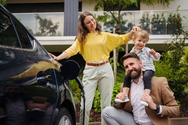 Lycklig Familj Som Står Bredvid Sin Elbil Och Laddar Den — Stockfoto