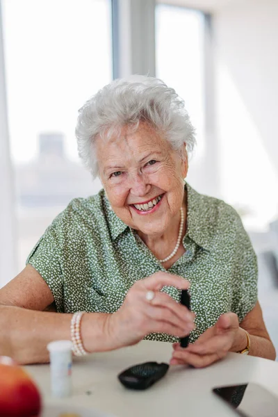 糖尿病老年患者用指尖测血糖仪检查血糖水平的特征 1型糖尿病老年妇女在家中使用血糖监测仪的特征描述 — 图库照片