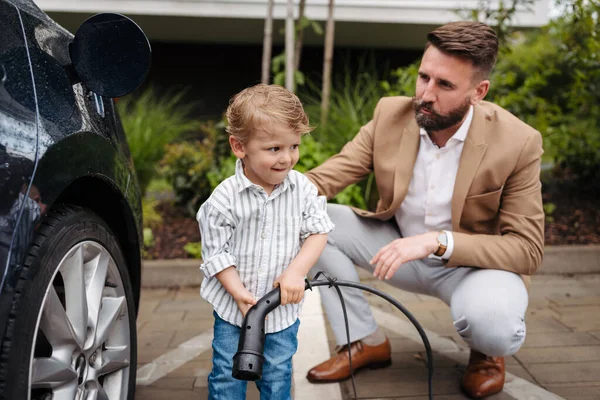 Smiling Father His Little Son Charging Electric Car Street Cute — Stock Photo, Image