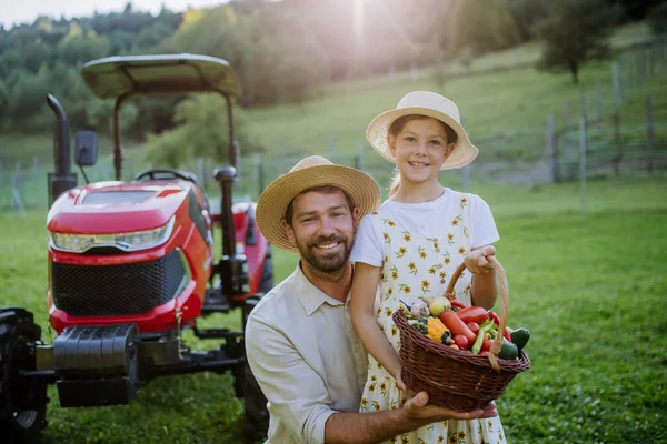 新鮮な野菜でいっぱいの収穫バスケットを持っている娘と農家の父の肖像画 農作物を収穫し 農場で野菜を集めている 多世代農業の概念 — ストック写真